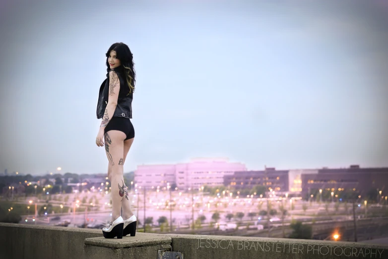 a woman standing on the edge of a wall