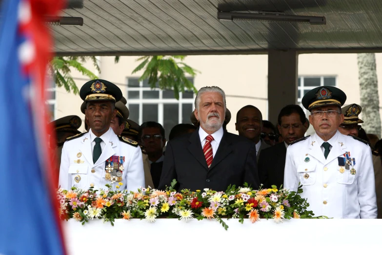 men wearing uniforms and standing around a table