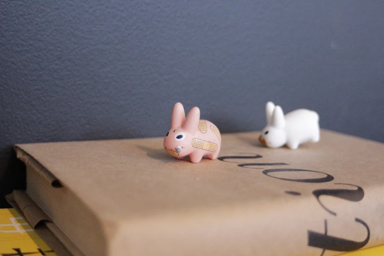 two rabbits sitting on top of an open box