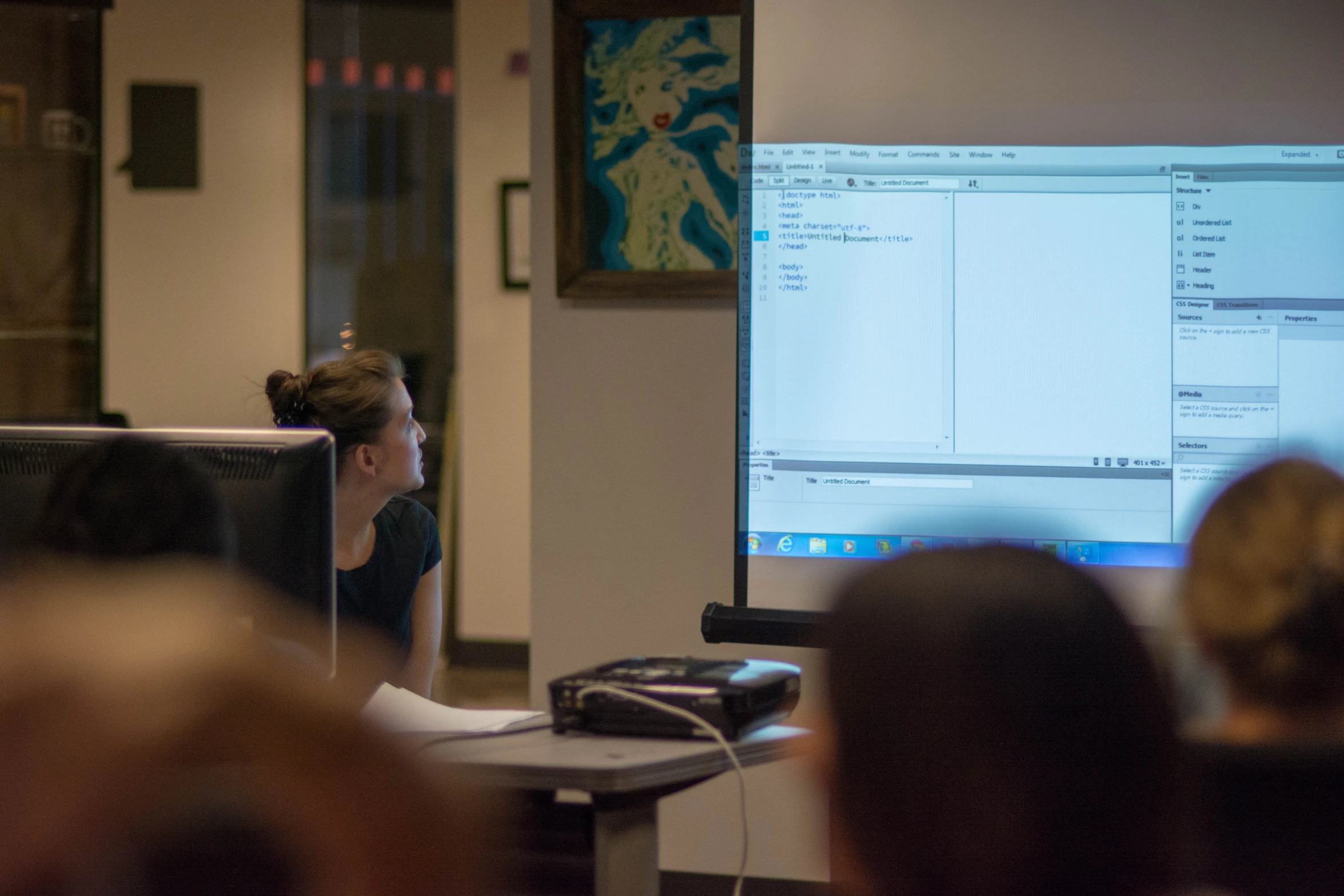 woman on a laptop in front of a classroom