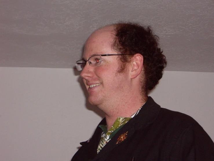 a man smiling wearing glasses and a flowery tie