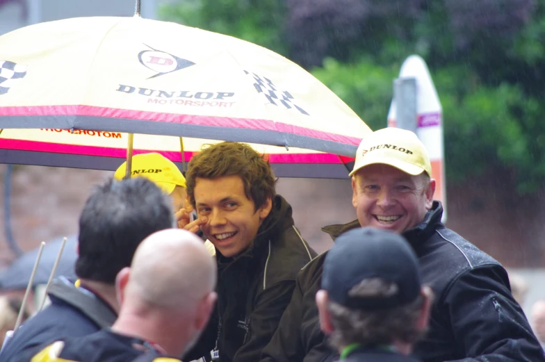 a man sitting on top of a yellow and pink umbrella