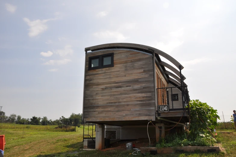 a large wooden house sits on top of a hill