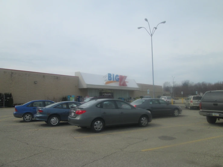 several cars are parked in the parking lot of a small store