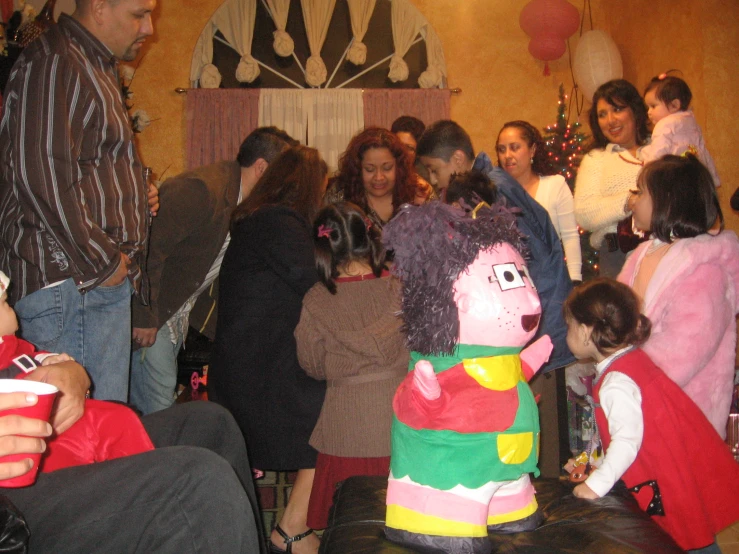 a group of people at an event with a stuffed toy in the center