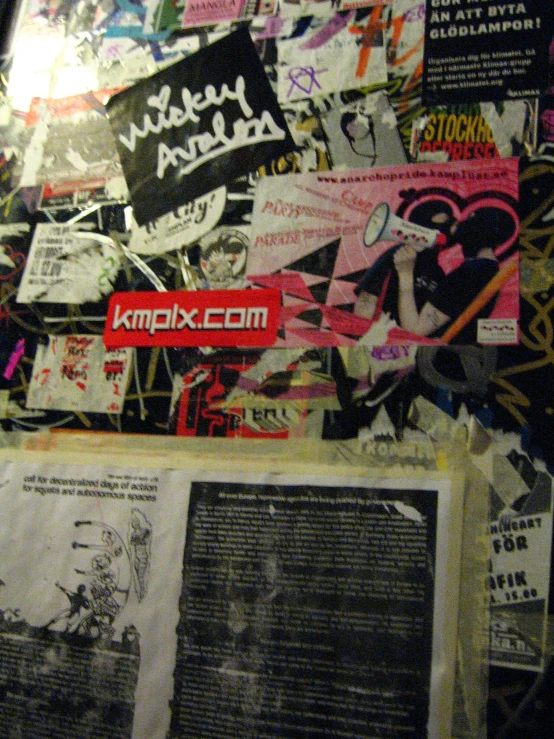 a paper covered wall with graffiti written on it