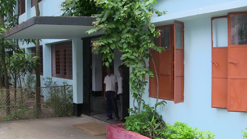 a couple of people standing inside of a building with red doors