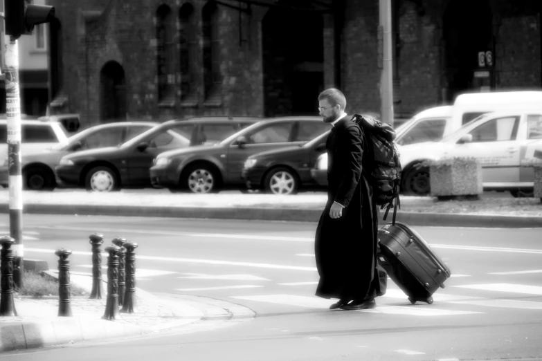 a man with a suitcase crosses the street