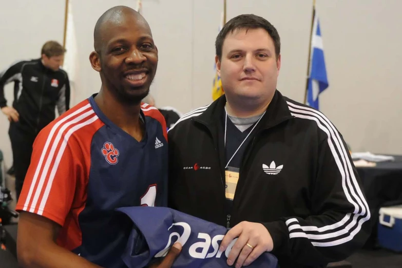 two men in jerseys smiling and posing for a po