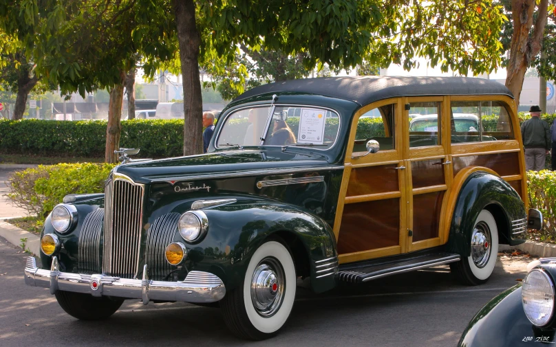 an old fashion car in front of some trees