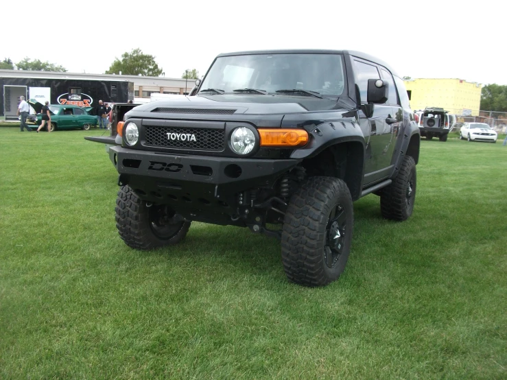 a black four - door toyota truck is parked at an event