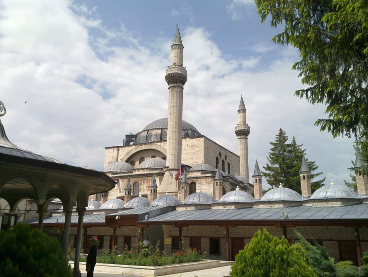 a mosque with two towers is surrounded by hedges