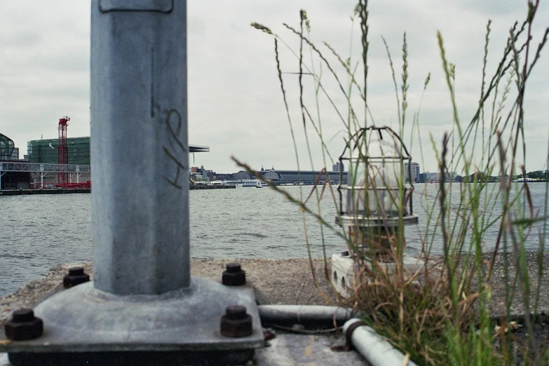 a view of the city of a town on the water from behind a pole