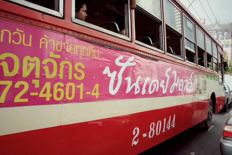 a red bus with yellow letters on the side