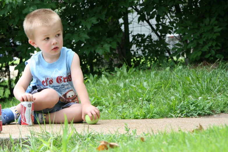 a small child sitting on the ground playing with some ball