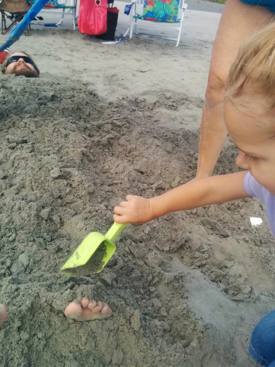 a small child playing in the sand with a toy