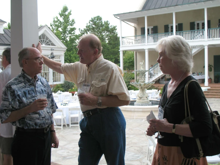 two adults and one elderly man standing outside