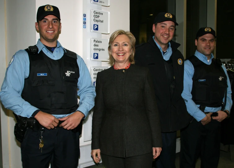 several police officers standing near the door to their cell phones