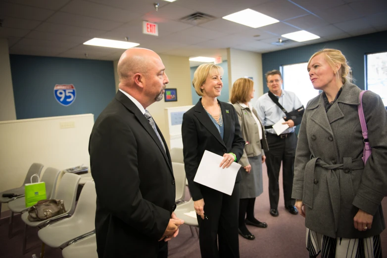 several people in a business office setting talking to each other