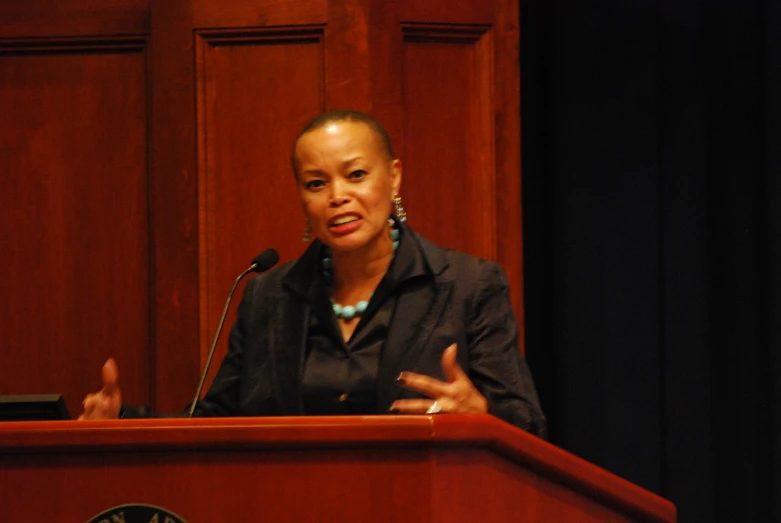 woman giving a speech while standing at a podium