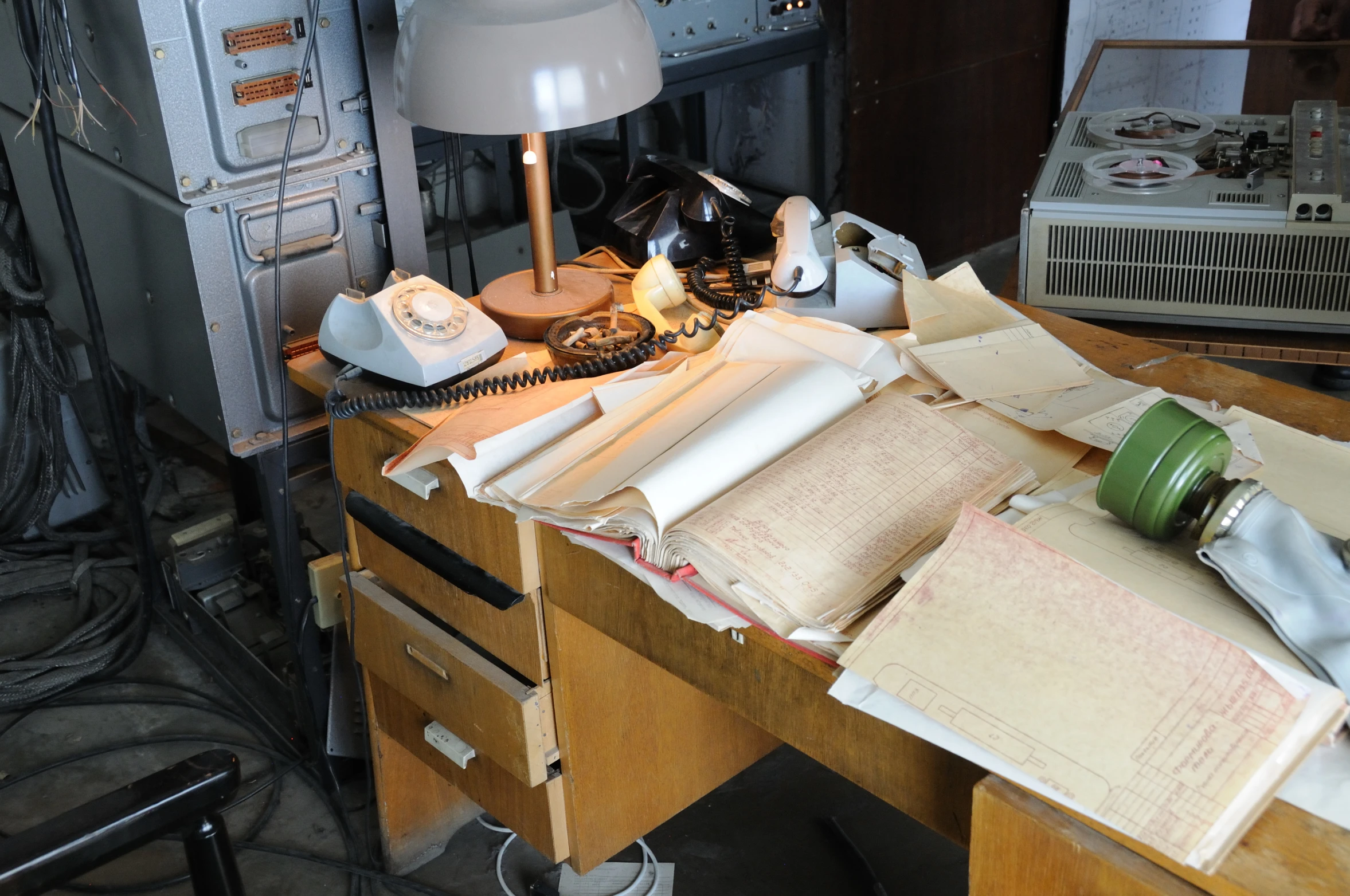 a desk with old records, a phone and a lamp on it