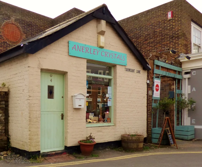 an old house with a green door and a store front