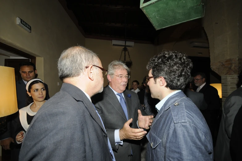 three men are talking to each other inside