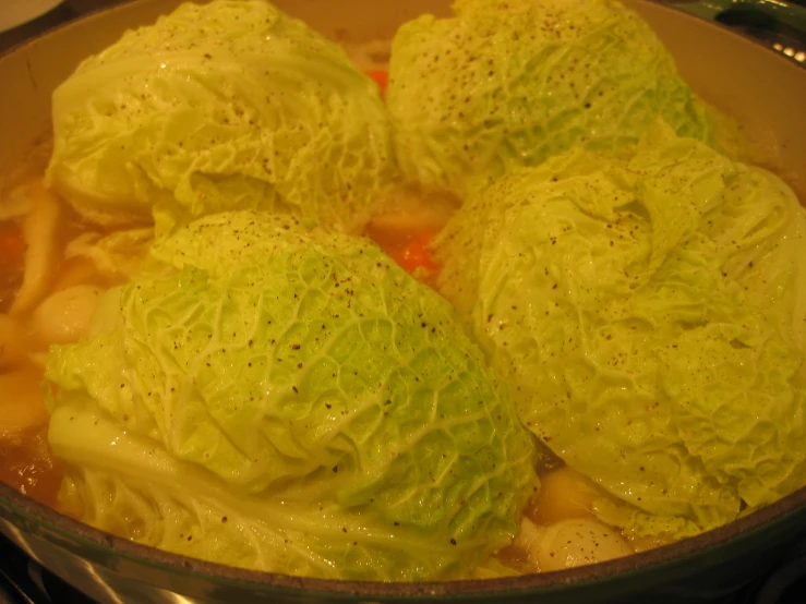 cabbage is simmering in a pot with a red handle