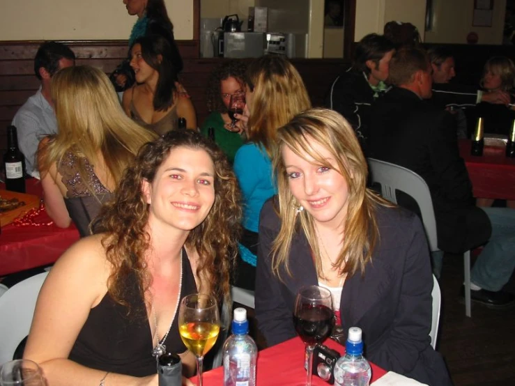 a couple of women sitting at tables eating food