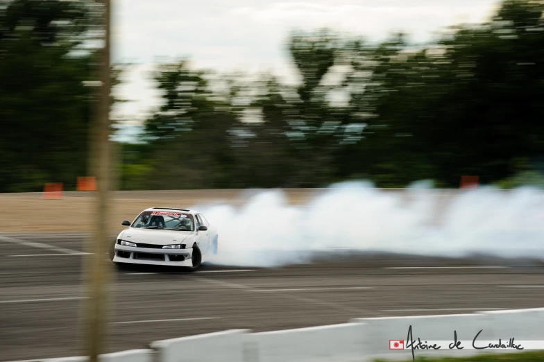 a car going around a corner with smoke coming out of it