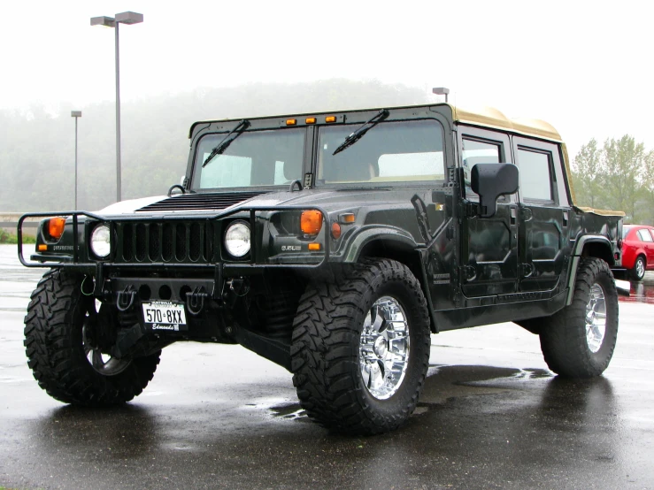 a hummer parked in a parking lot in the rain