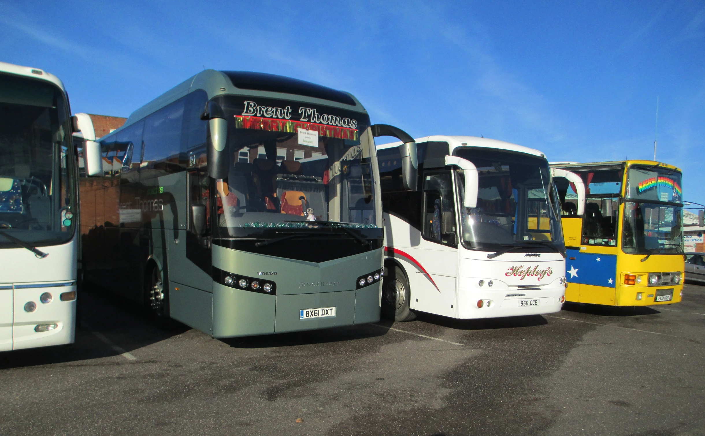 some very big pretty city buses in the parking lot