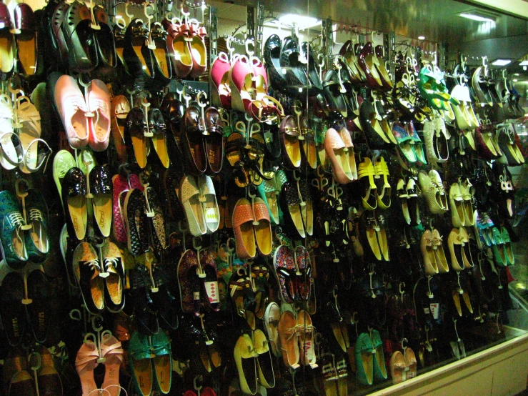 an assortment of shoes are hanging on a wall