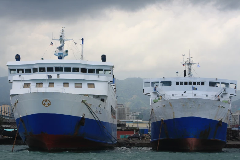 two very large boats side by side at a dock