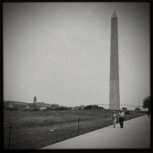 a couple of people walking down a sidewalk