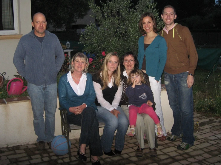 two adults and three s with one child on a bench