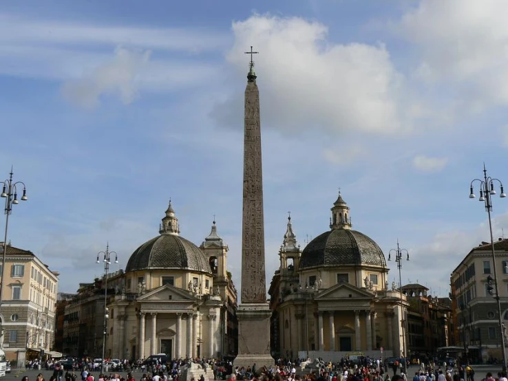 some people in front of an obelisk in a city