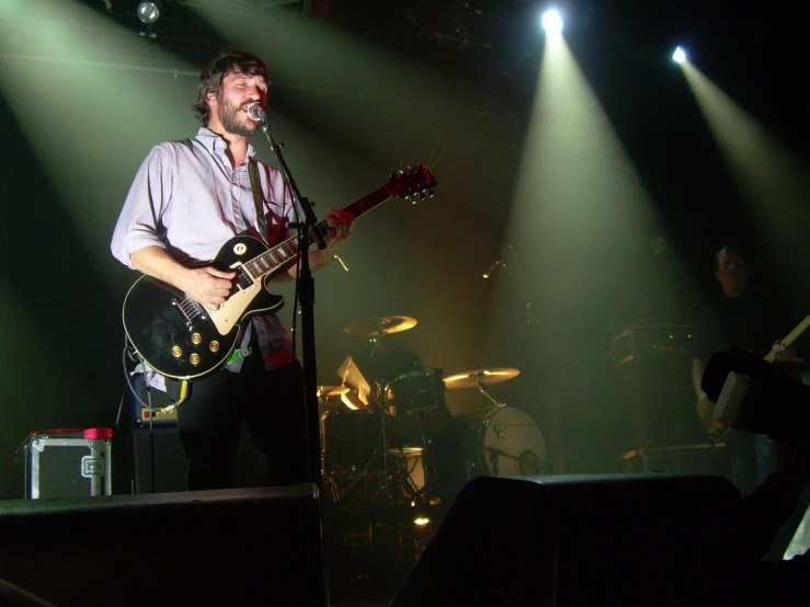 a guitarist singing on stage with an amp