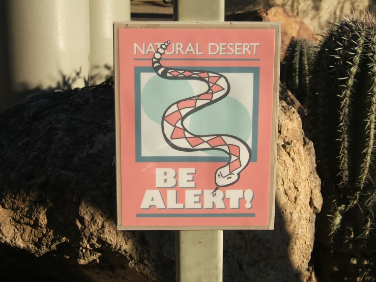 a sign with a snake on it is attached to a pole