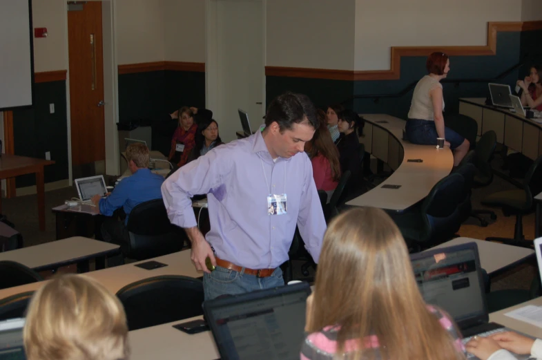 a man standing in front of some laptops