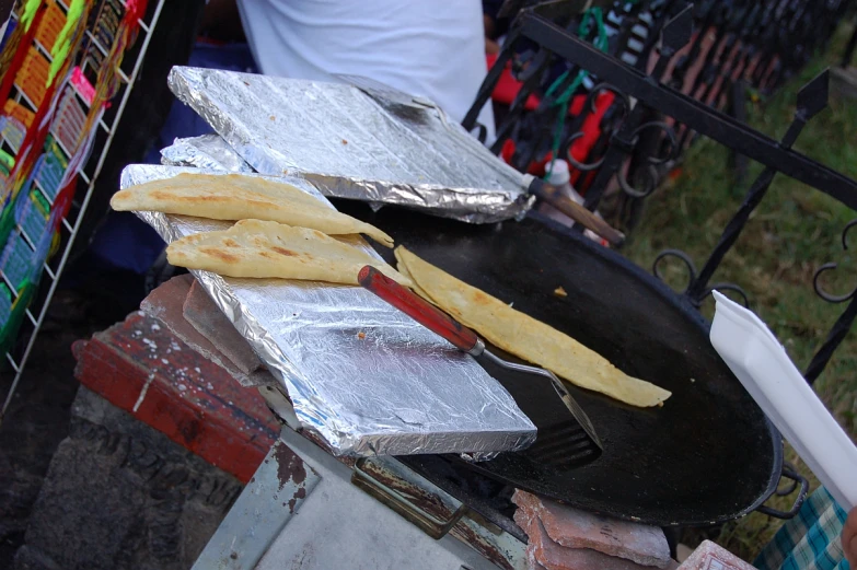 some food is being cooked on a black plate