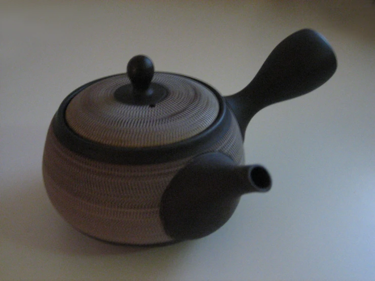 a teapot with handle on the top of a table