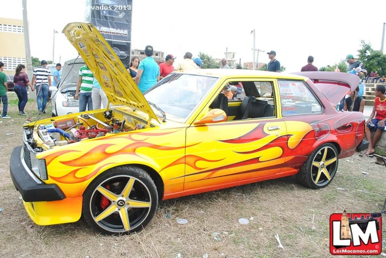 a yellow and orange car with flames painted on it