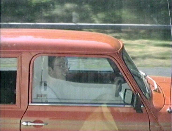 an old man driving in a red truck