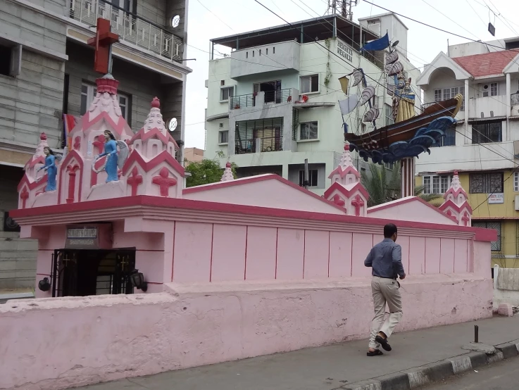 the skateboarder rides past an old pink building