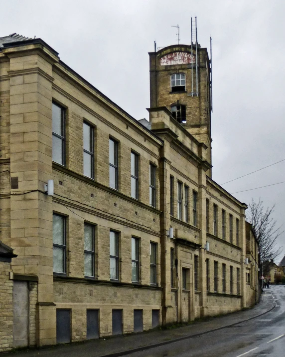 an old building on the corner of a wet road