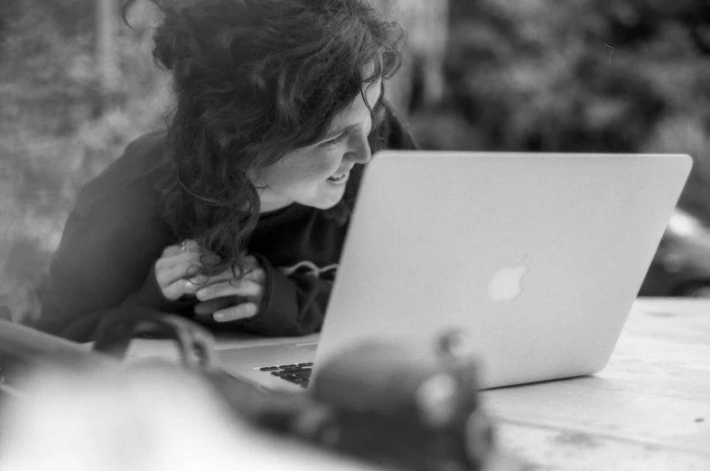 a woman using her apple laptop on a table