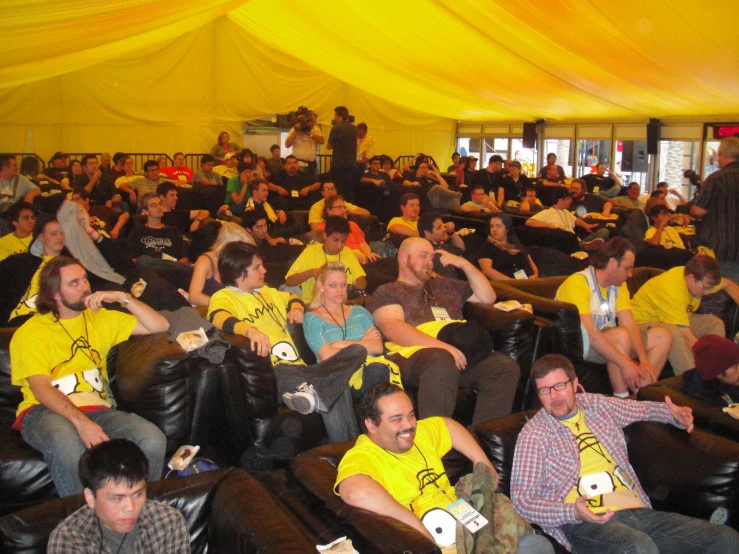 a large group of people sitting down in seats with game controllers