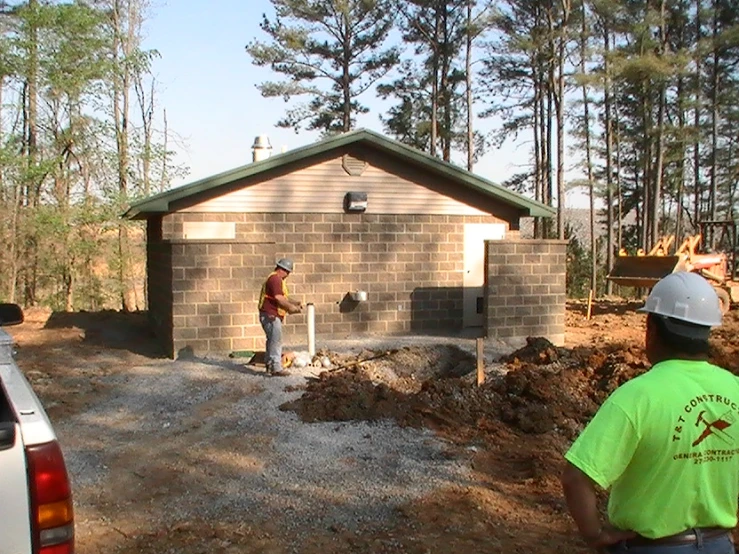 two workers are looking at a small garage