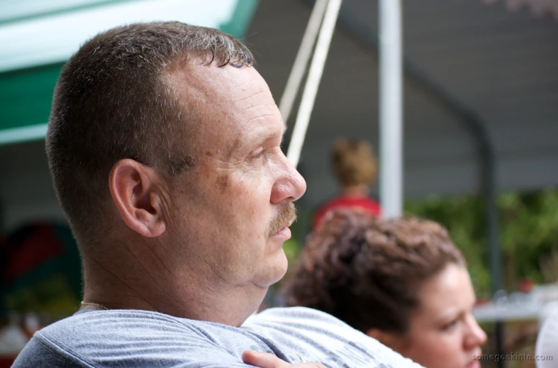 a man sitting on a bench with his arm around another man's shoulder